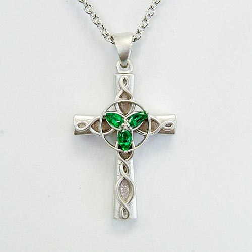Custom jewelry featuring green gemstones in a silver cross pendant necklace.