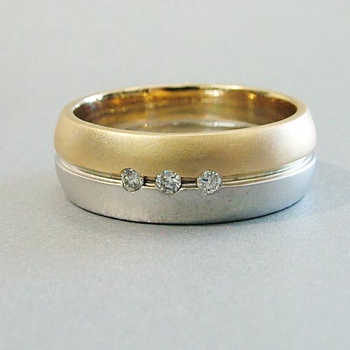 Custom men’s engagement ring in yellow and white gold with small flush-set diamonds.
