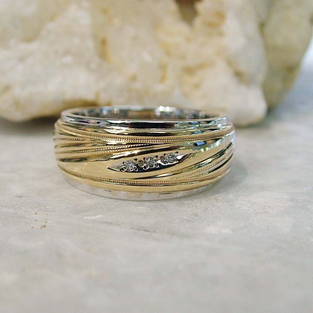 Mixed metal custom men’s engagement ring combining yellow and white gold with textured detailing.