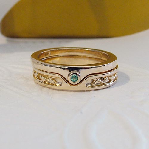Custom men’s engagement ring designed to merge with a wedding band, featuring gold detailing and a center gemstone.