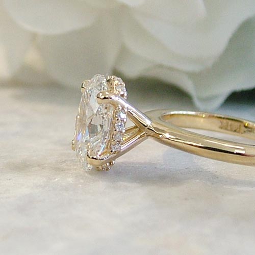 Side profile of an oval diamond engagement ring in yellow gold, showcasing the most popular engagement ring style.