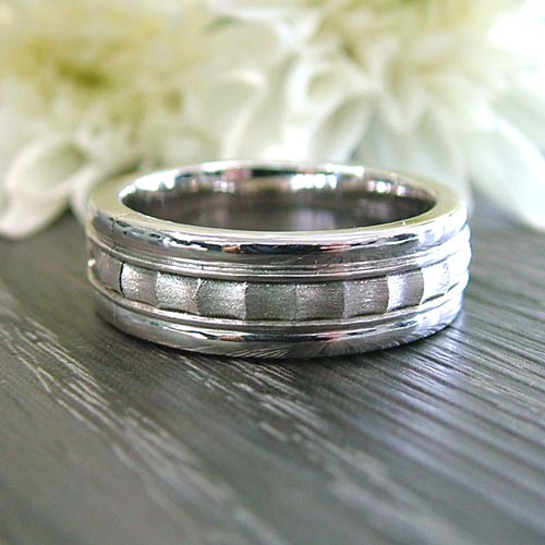 Modern custom men’s engagement ring in white gold with layered grooved detailing.