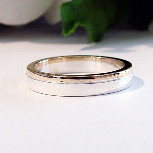 Minimalist custom men’s engagement ring in rose gold with a polished white gold center stripe.